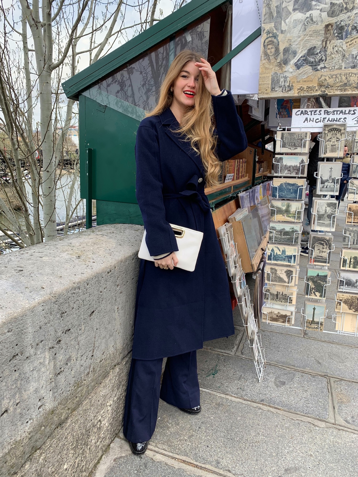 Constance Arnoult wearing a navy wool coat near the bouquinistes of Paris