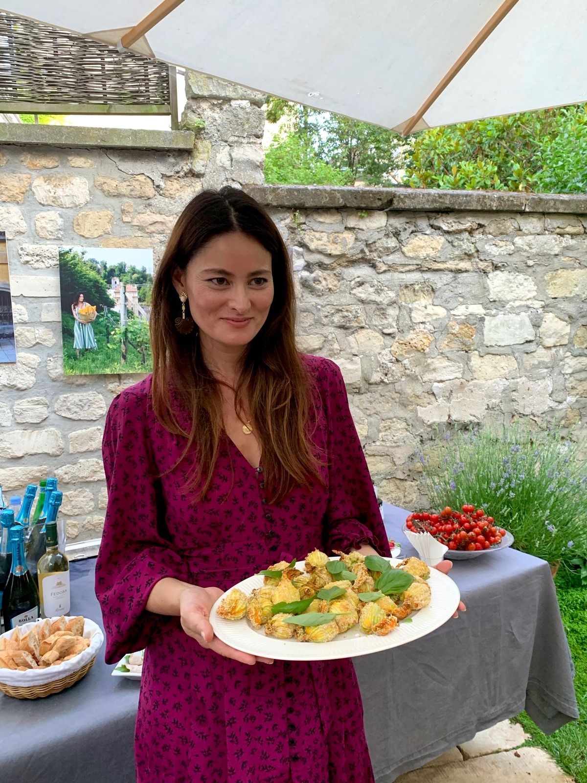 Mimi Thorisson holding a dish she cooked, wearing a Mirae dress